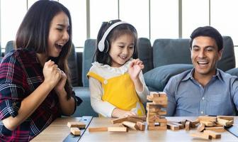 Mixed race family, daughter and caucasian dad and Asian mom, playing wood game together with fund and excited. photo