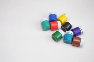 Closed jars with gouache of different colors on a light background. Creativity, hobby. photo