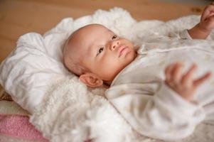 Cute baby boy in a white light bedroom Newborn baby is cute. In bedding for children born - images photo