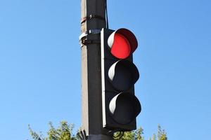 street tricolor traffic light with a burning red light photo