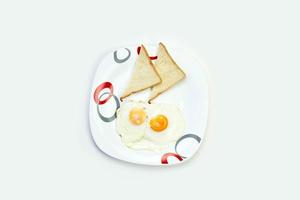 desayuno con huevos y tostadas en mesa blanca