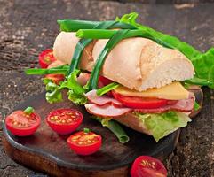 Sandwich with ham, cheese and fresh vegetables photo