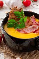 Cream of pumpkin soup with bacon and croutons