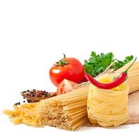 espaguetis de pasta, verduras, especias aisladas en blanco foto