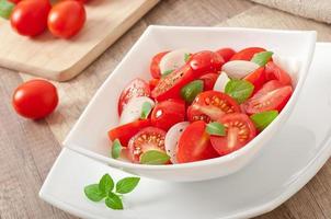 tomato cherry salad with basil, black pepper and onion photo