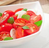 tomato cherry salad with basil, black pepper and onion photo