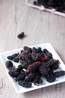 fresh mulberries on wooden background photo