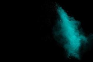 Green color powder explosion on black background. photo