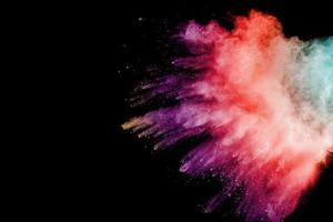 Explosion of color powder on black background. Splash of color powder dust on dark background. photo
