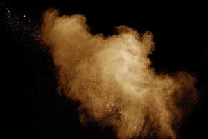 Abstract orange dust explosion on  black background. photo