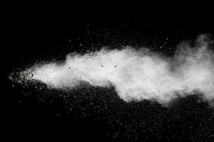 Bizarre forms of white powder explosion cloud against black background.White dust particles splash. photo