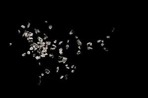 Split debris of stone exploding against black background. photo