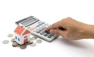 House and calculator and hand on white background photo