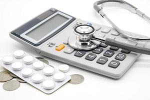 Calculator and stethoscopes on white background photo