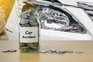 ahorro de dinero por accidente automovilístico en la botella de vidrio foto