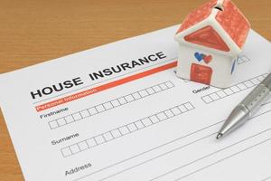 House Insurance application form with model house and pen photo