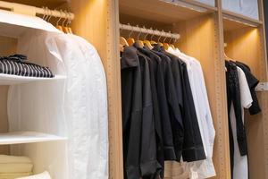 Fashion t-shirt hanging on metal rack in wardrobe closet with led light photo