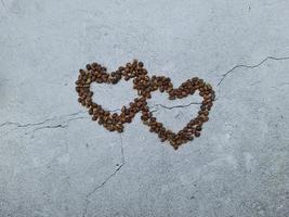 Love or Valentine concept. Closed up coffee beans in heart shape on isolated grey wallpaper background photo