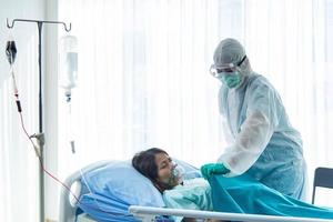 Doctors in protective suit  taking care patient infected with CORONA VISRUS or COVID-19  is in quarantine room at the hospital. photo