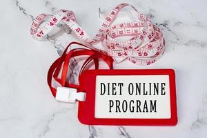 Diet online program text on a red name tag with measure tap on white desk. photo