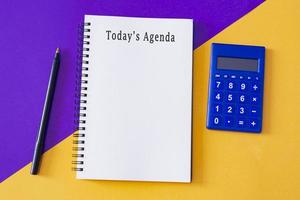 Today's agenda text on notepad on colored background photo