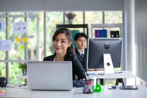 Portrait of Asian beautiful business woman working at the office, using computer on table. photo