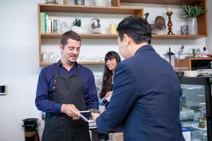 Customer use mobile phone scanning QR code for pay in cafe, Customer paying with qr code on smartphone. photo