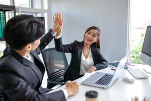 Teamwork Deal Cooperation Partnership business people giving hi-five after successful work in the office. photo