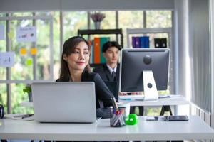 Portrait of Asian beautiful business woman working at the office, using computer on table. photo