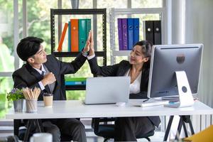 Teamwork Deal Cooperation Partnership business people giving hi-five after successful work in the office. photo