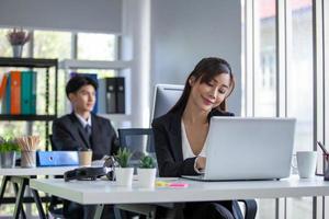 Portrait of Asian beautiful business woman working at the office, using computer on table. photo