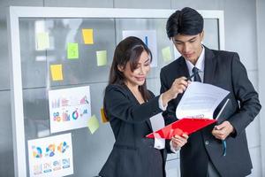 los colegas masculinos y femeninos del equipo de negocios que hablan en el trabajo comparten ideas con una computadora portátil, los colegas jóvenes felices trabajan juntos en la computadora foto