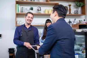 Customer use mobile phone scanning QR code for pay in cafe, Customer paying with qr code on smartphone. photo