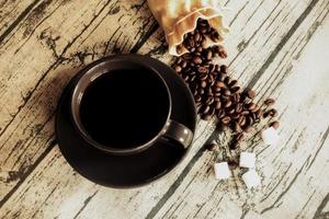 Cup of coffee with beans on a wooden table linen fabric. photo