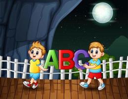 Happy boys holding ABC letter in the night landscape vector