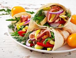 Fresh tortilla wraps with meat and vegetables on plate photo