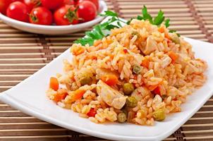 Pilaf with chicken, carrot and green peas photo