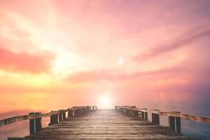 A wooden bridge jutting out into the sea with a beautiful view. photo