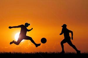 Silhouette of football players in the evening. Football concept is popular all over the world. photo