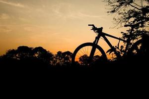 silueta de una bicicleta de montaña por la noche. ideas de fitness y aventura foto