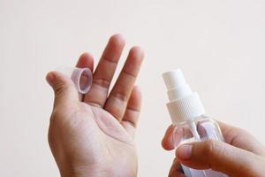 Women's hands using alcohol spray or antibacterial spray to prevent the spread of germs, bacteria and viruses.