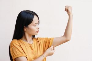 las mujeres asiáticas usan sus manos en la piel debajo de sus brazos para ver si tienen mucha grasa o flacidez. foto