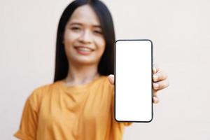 Concept of use of the smartphone. A smartphone with a white blank screen in the hands of a woman.