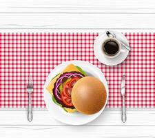 Hamburger with tableware and cup of black coffee on wooden table