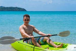 hombre adulto haciendo kayak en el mar azul en verano foto