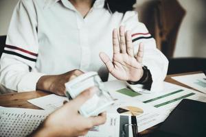 The auditor shows a gesture of refusing to receive money from the bribery of the officer. photo