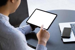 A man holding a tablet with a blank white screen. The blank space on the white screen can be used to write a message or place an image. photo