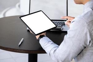 A man holding a tablet with a blank white screen. The blank space on the white screen can be used to write a message or place an image. photo