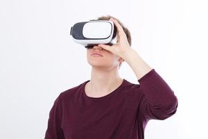 Portrait of young man wearing virtual reality goggles isolated on white background. Copy space and mock up. Smartphone and VR headset. Horizontal image photo