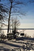 a winter camp site on the shore of a lake photo